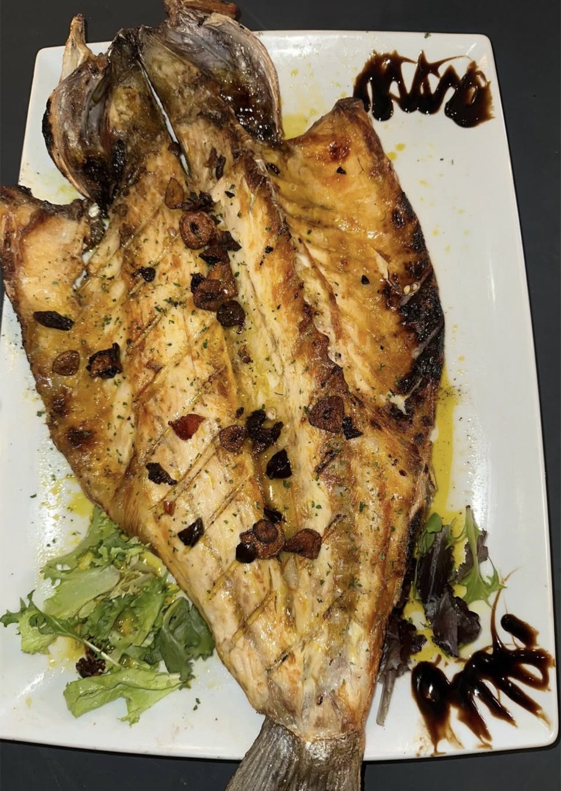 Pescado a la brasa abierto y emplatado